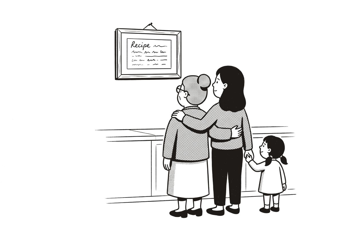 A grandmother, her daughter and a small child looking up at a framed recipe card on the kitchen wall.