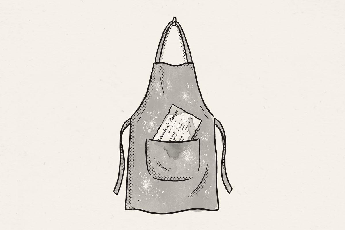 A floury apron on a hook with a stained recipe card in its pocket.