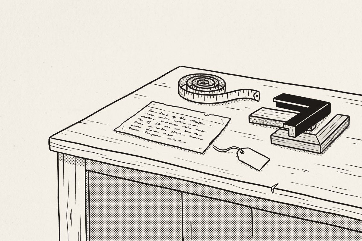 A handwritten recipe card on a framer's counter beside a tape measure, frame samples and a blank price tag.