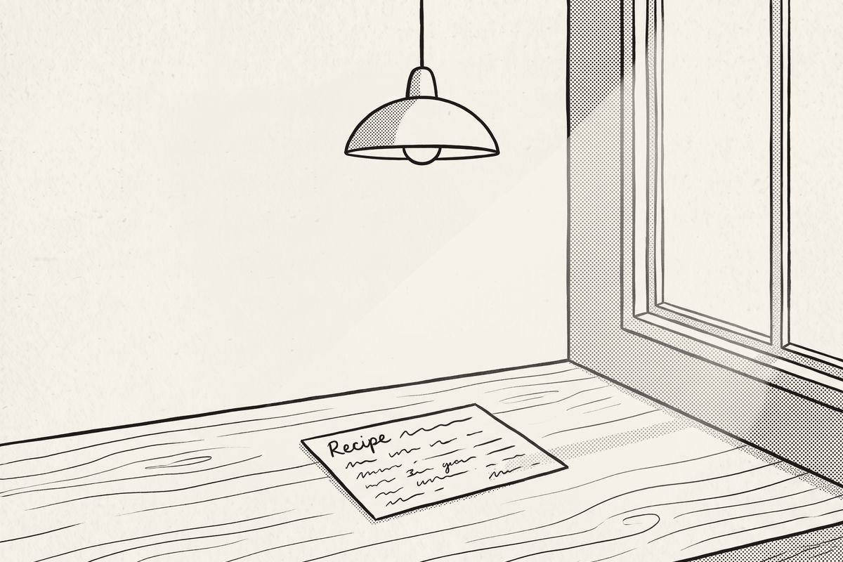 A recipe card on a table beside a window, the ceiling lamp switched off.