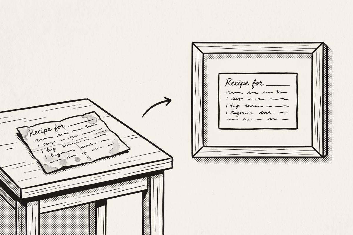 A worn recipe card on a table and the same handwriting framed on the wall.