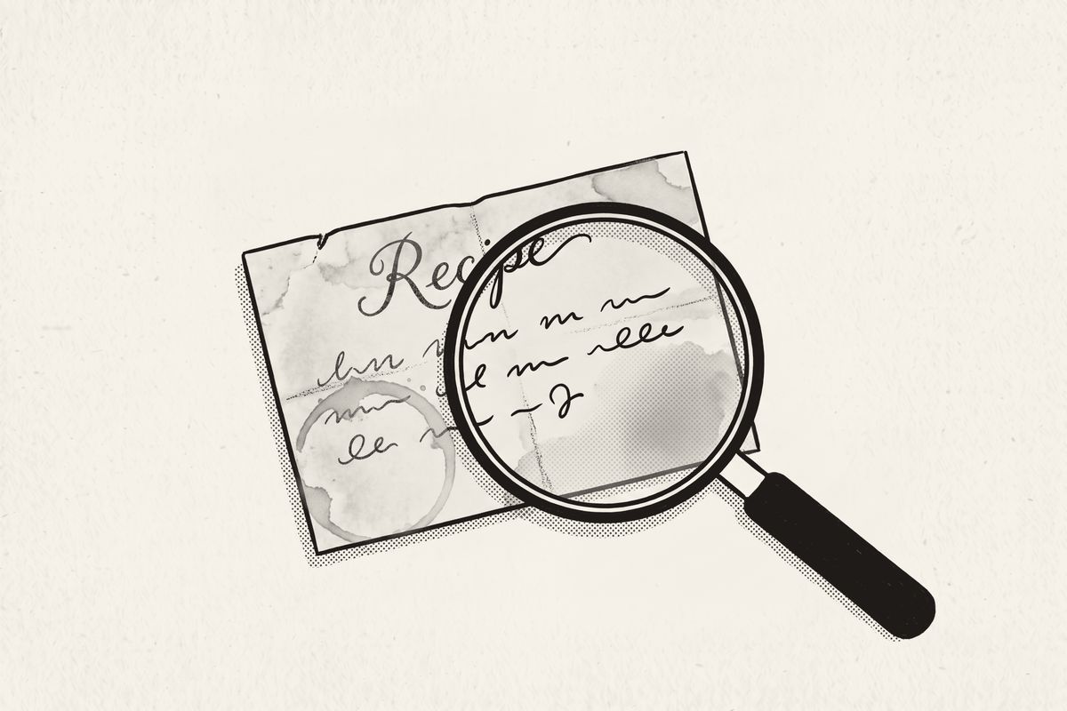 A magnifying glass over a worn recipe card, the handwriting crisp inside the lens.