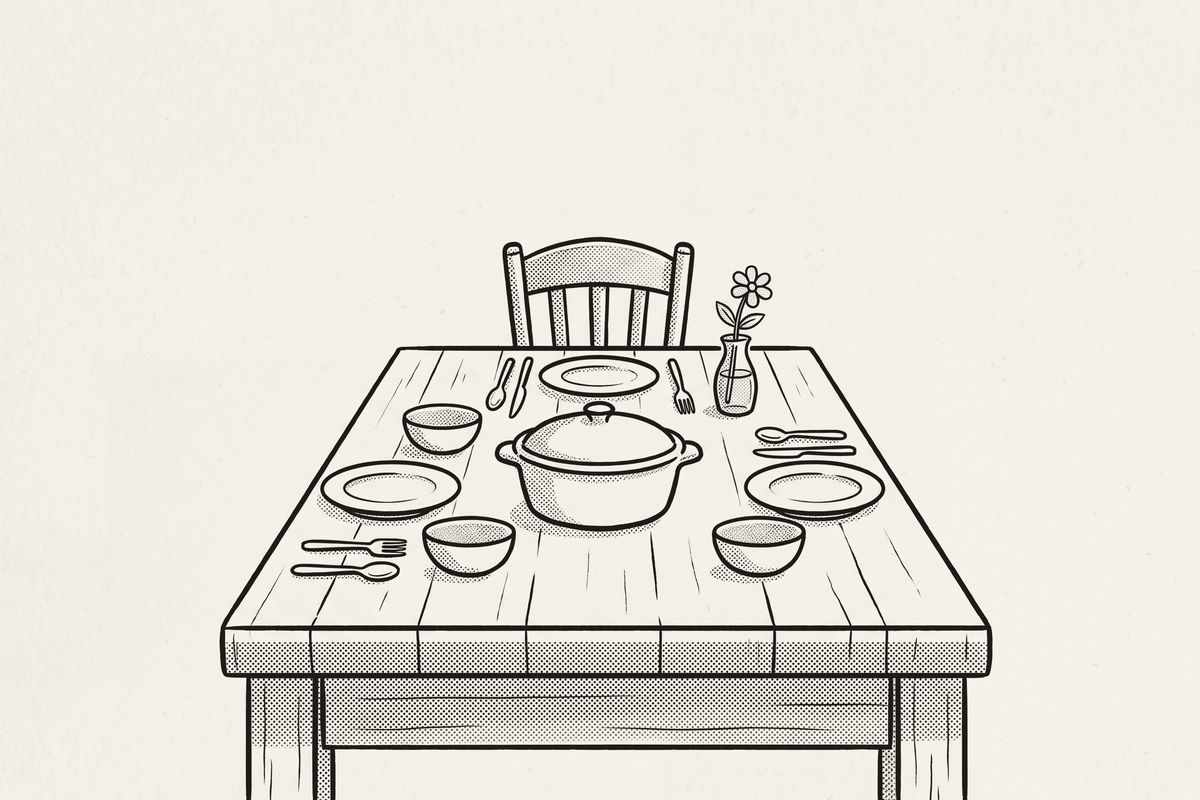 A family table set for a meal, one chair empty, a casserole dish in the middle.