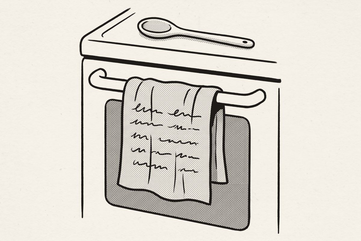 A tea towel printed with a handwritten recipe, hanging from an oven door.