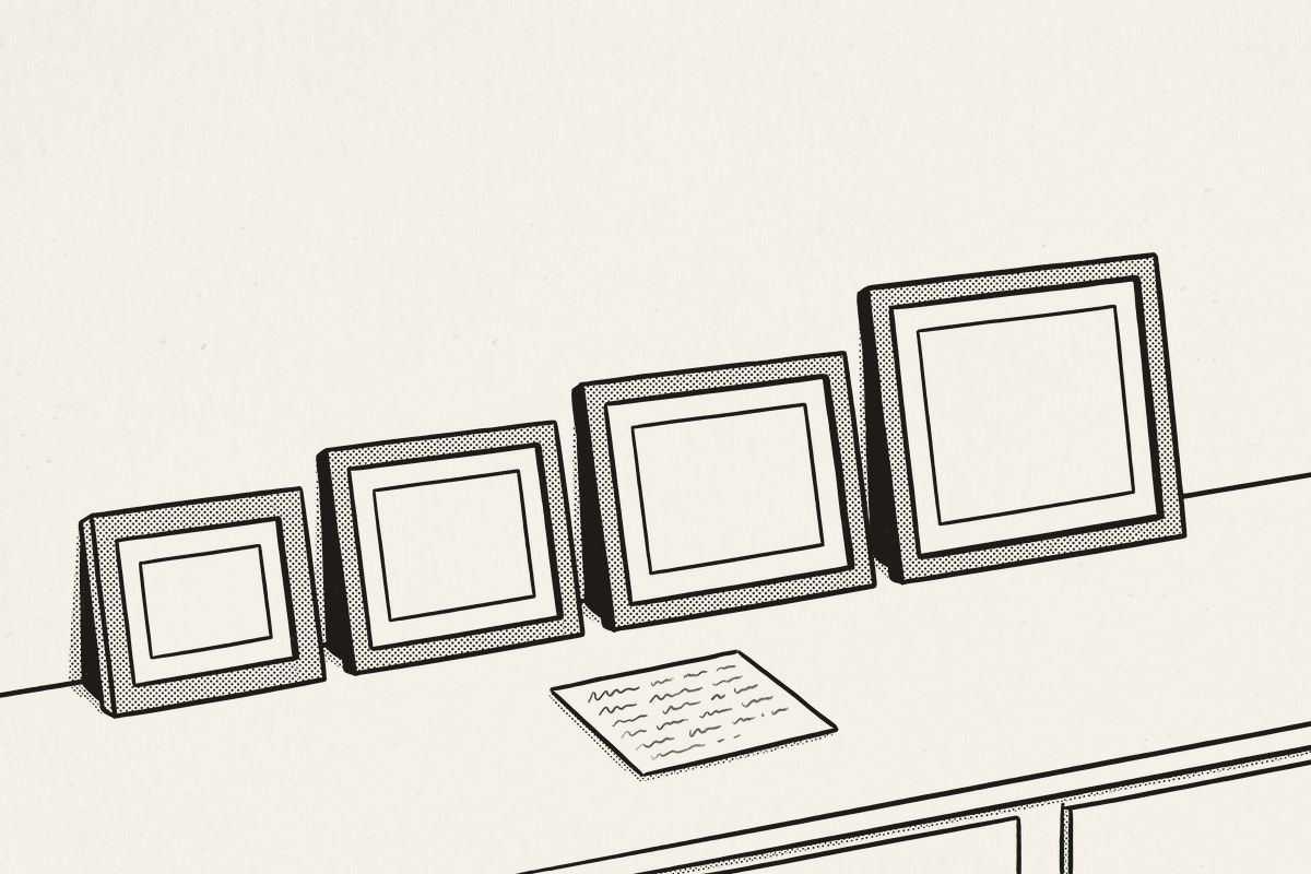 Four empty frames in four sizes leaning against a kitchen wall, a small recipe card on the counter in front.